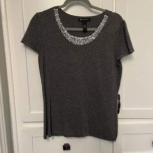 Charcoal gray sweater with jewel embellishment.